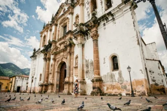 Cathédrale baroque de León au Nicaragua avec une femme en robe fleurie admirant la façade coloniale sur une place pavée