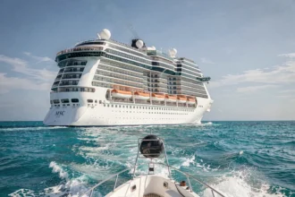 Grand navire de croisière MSC en pleine mer vue depuis un canot, illustrant un tour du monde en croisière